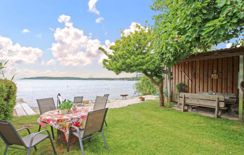 a table and chairs on a lawn next to the water at Ferienwohnung Waren Müritz in Waren