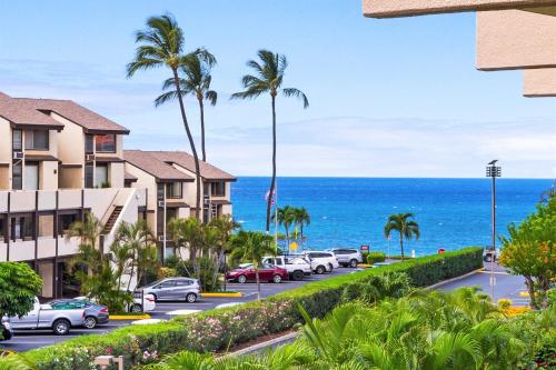 a view of a parking lot with palm trees and the ocean at Rear Ocean View 2 Bedroom Single Level Condo at Kamaole Sands 9-305 in Wailea