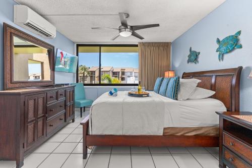 a bedroom with a bed and a dresser and a mirror at Rear Ocean View 2 Bedroom Single Level Condo at Kamaole Sands 9-305 in Wailea