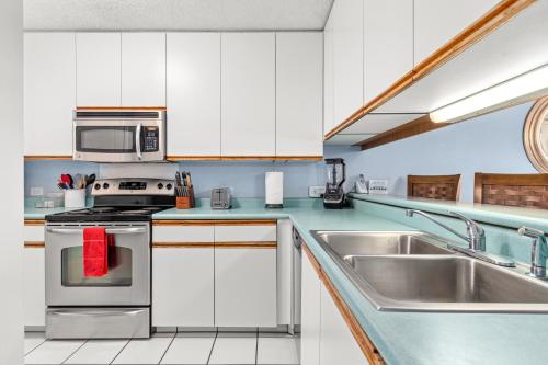 a kitchen with white cabinets and a stainless steel appliance at Rear Ocean View 2 Bedroom Single Level Condo at Kamaole Sands 9-305 in Wailea