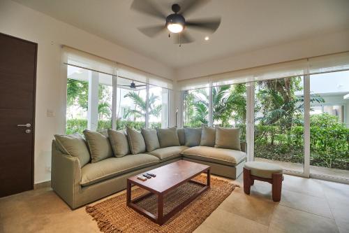 una sala de estar con un sofá y una mesa en Aldea Zama Condo with 2 Pools, Gym, Yoga Deck and BBQ Grill, en Tulum