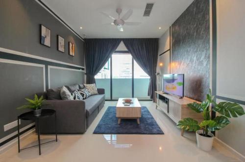 Una sala de estar con un sofá y un televisor. en Suasana Suites, en Johor Bahru