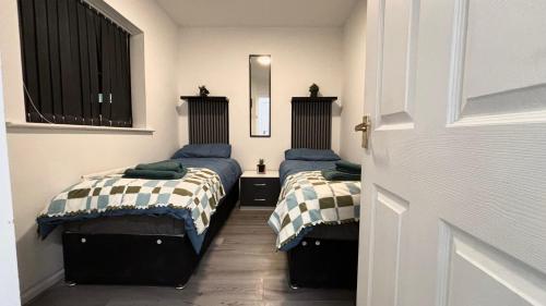 2 Betten in einem kleinen Zimmer mit einer Tür in der Unterkunft 2-Bed House by Knighthead Park w- FREE Parking & FREE MATCHDAY DROP-OFF in Birmingham