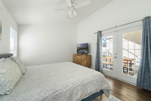a white bedroom with a bed and a window at Luxury 4-Bedroom Home with Private Pool, Jacuzzi, AC, Wi-Fi, Cable TV, 5 Minutes from Disney in Kissimmee