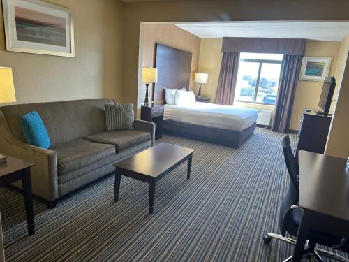 a hotel room with a couch and a bed at Wingate by Wyndham Harrisburg Near Hershey in Harrisburg