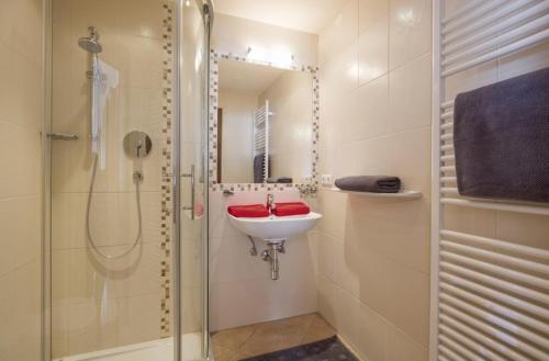 a white bathroom with a sink and a shower at Haus Drei Linden in Going