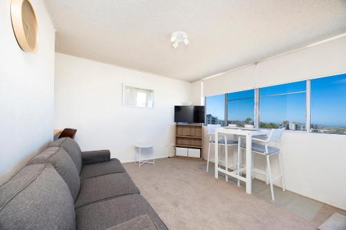 a living room with a couch and a table at Ebbtide 40 in Forster