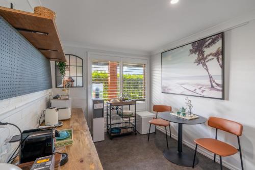 a kitchen with a table and chairs in a room at Kiama Mountain Views Studio in Kiama