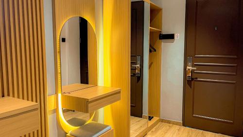 a room with a mirror and a chair next to a door at Eagle Hotel Wonosobo, Azana Hotels Collection in Kalianget