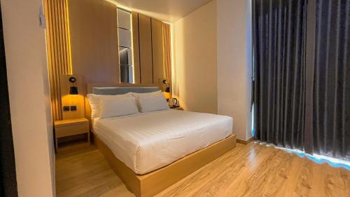 a small bedroom with a bed and a window at Eagle Hotel Wonosobo, Azana Hotels Collection in Kalianget