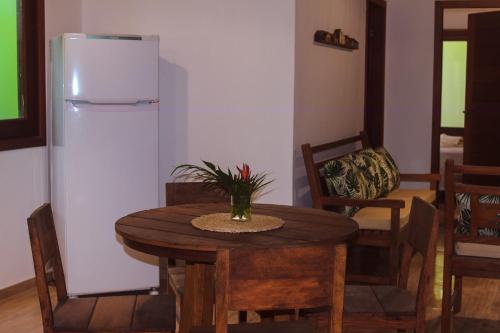 a dining room with a table and a refrigerator at Village da Mata Arraial in Porto Seguro
