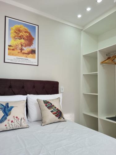 a bedroom with a large bed with white walls at Ipê Amarelo - Frente ao Mar na Praia de Meaípe, Guarapari in Guarapari