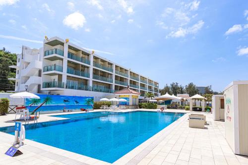 a large swimming pool in front of a hotel at Kariyushi LCH. Resort in Nago