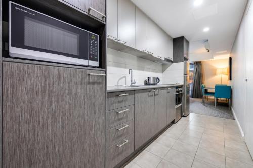 una cocina con fregadero y microondas en Hudson Berrimah, en Darwin