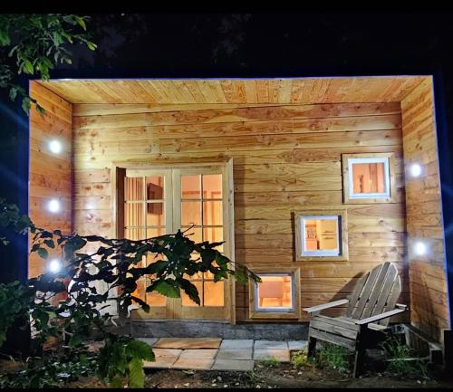 a wooden cabin with a bench and a window at Tiny house in Coñaripe