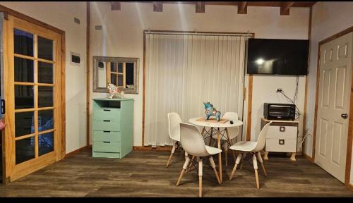 a room with a desk and a table and chairs at Tiny house in Coñaripe