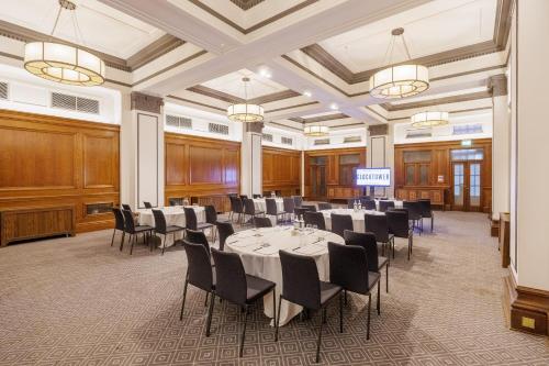 a meeting room with tables and chairs in a hall at Kimpton Clocktower by IHG in Manchester