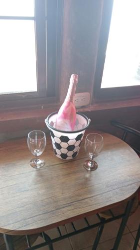 un pollo en un tazón en una mesa con dos vasos en Cabana 1 Estrellas, en Chicá