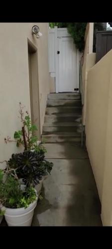 an alley with potted plants on the side of a building at Nearby Beach House in El Segundo
