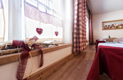 a room with a window with hearts on the window treatments at Garnì Aurora Bed and Breakfast in Soraga