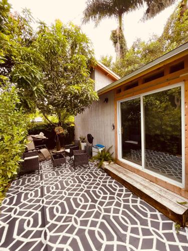 a patio with a rug on the side of a house at Bienvenidos a la Pequeña Selva de Legnalife in Homestead