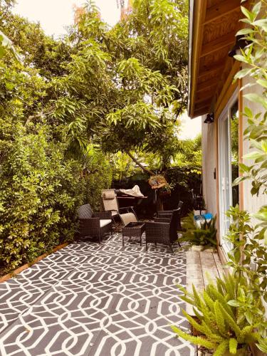 a patio with chairs and a table and trees at Bienvenidos a la Pequeña Selva de Legnalife in Homestead