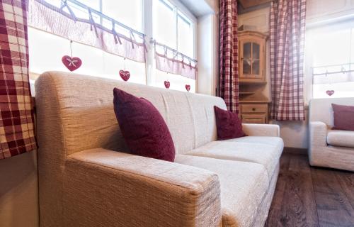 a living room with a white couch and purple pillows at Garnì Aurora Bed and Breakfast in Soraga