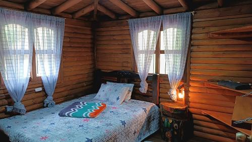 a bedroom with a bed in a log cabin at Finca la carolina in Medellín