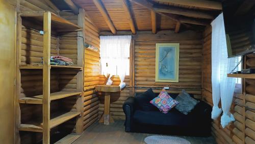 a room with a couch in a log cabin at Finca la carolina in Medellín