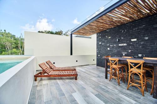 an outdoor patio with a table and chairs and a pool at Luxury Villa with 2 Pools, Open Terraces and Sun Deck in Tulum