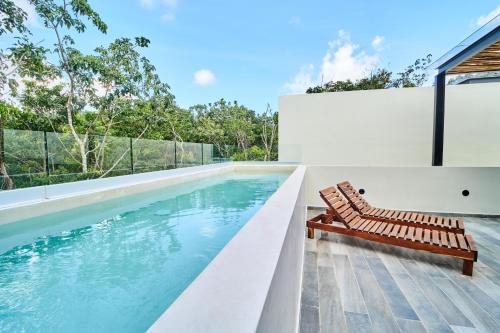 a swimming pool with a bench next to a house at Luxury Villa with 2 Pools, Open Terraces and Sun Deck in Tulum