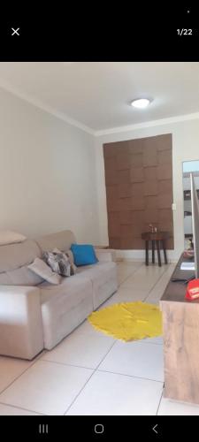 a living room with a couch and a table at Casa Aconchegante Votuporanga in Votuporanga