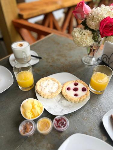 a table with a plate of pastries and orange juice at Ecos del Manantial in Villarrica
