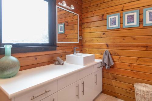 a bathroom with a sink and a mirror at Lavendula Garden Cottage in Burnt Pine