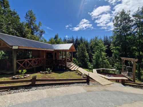 a wooden cabin with a wooden walkway in the woods at Ecos del Manantial in Villarrica