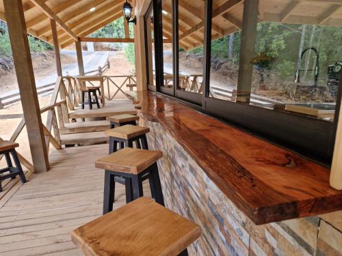 a porch with wooden stools in a building at Ecos del Manantial in Villarrica