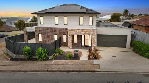 una casa con una recinzione nera davanti di Sunrise To Sunset Getaway By Wine Coast Holidays a Port Noarlunga