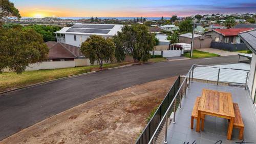 un tavolo sul balcone di una casa con strada di Sunrise To Sunset Getaway By Wine Coast Holidays a Port Noarlunga
