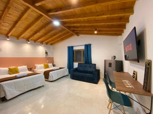a large living room with two beds and a table at Casa Dorada - Confort a solo una cuadra del Parque in Carmen de Viboral