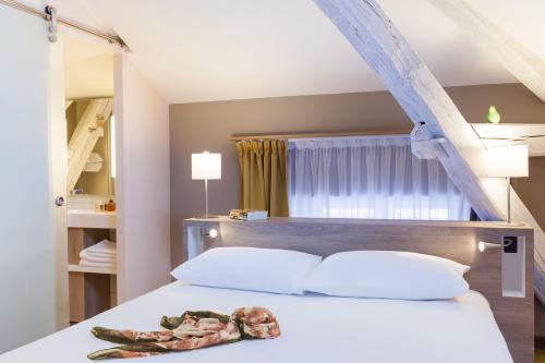 a bedroom with a bed with a snake on it at ibis Styles Chaumont Centre Gare in Chaumont