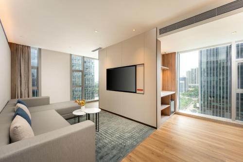 a living room with a couch and a tv at Holiday Inn Express Shenzhen Guangming by IHG in Shenzhen