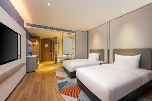 a hotel room with two beds and a flat screen tv at Holiday Inn Express Shenzhen Guangming by IHG in Shenzhen