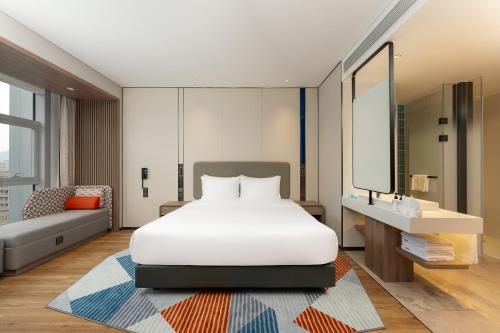 a bedroom with a white bed and a mirror at Holiday Inn Express Shenzhen Guangming by IHG in Shenzhen