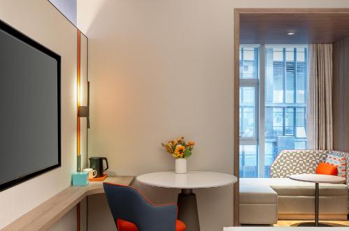 a small living room with a table and a couch at Holiday Inn Express Shenzhen Guangming by IHG in Shenzhen