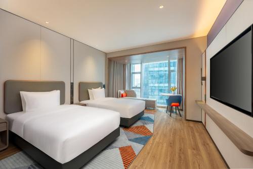 a hotel room with two beds and a flat screen tv at Holiday Inn Express Shenzhen Guangming by IHG in Shenzhen