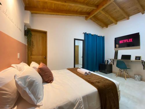 a bedroom with a large bed and a television at Casa Dorada - Confort a solo una cuadra del Parque in Carmen de Viboral