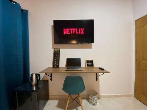 a desk with a laptop and a television on a wall at Casa Dorada - Confort a solo una cuadra del Parque in Carmen de Viboral