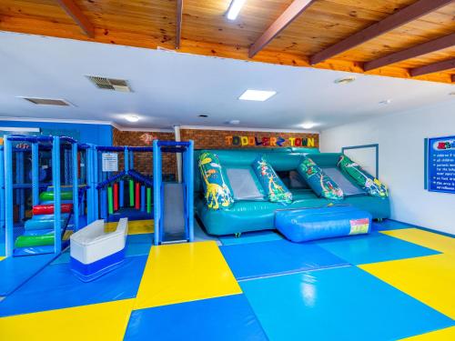 a play room with a blue and yellow play equipment at NRMA Blue Dolphin Yamba Holiday Resort in Yamba