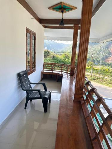 a living room with a chair and a balcony at Mountain Breeze Resort Vattavada in Munnar