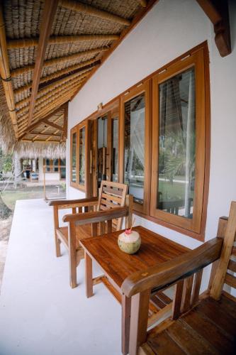 a porch with benches and a table on a house at Island View Bar & Bungalow in Gili Air